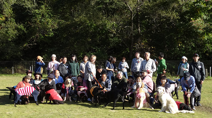 木々を前に、参加者と犬たちで集合写真