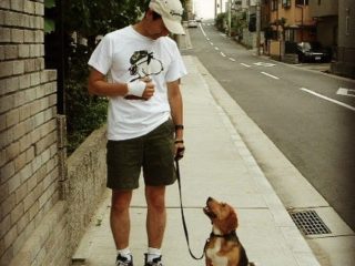 お散歩中にアイコンタクトを取る人と犬の写真