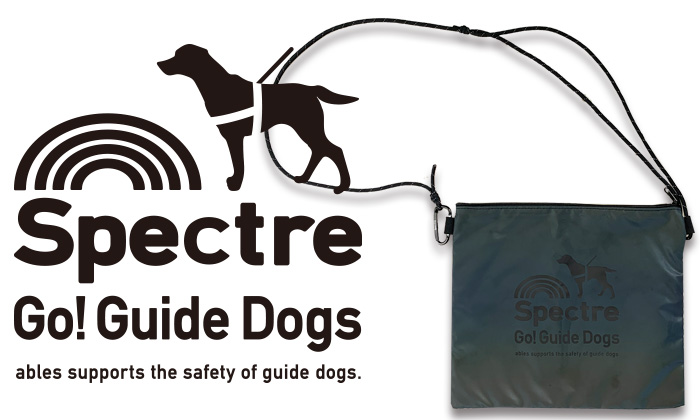 サコッシュを置いた画像。左にロゴが表示されている。盲導犬の立ち姿のシルエットの下に、スペクトルゴーガイドドッグスのロゴ。