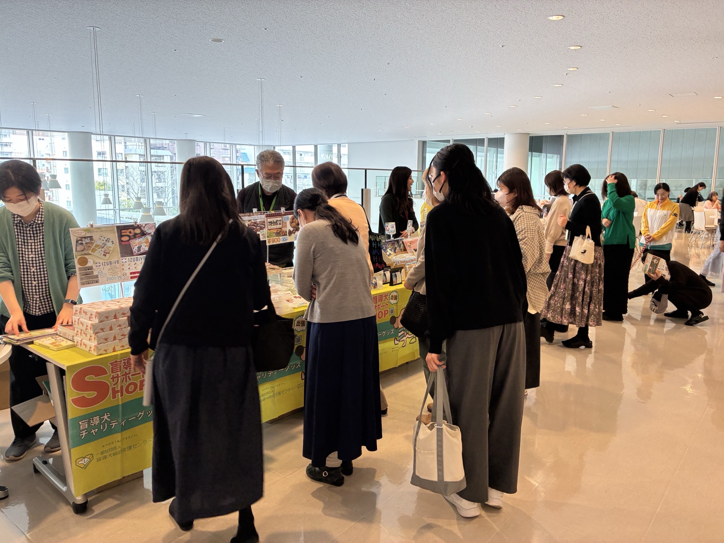 グッズが並ぶテーブルに、多くの人が立ち寄っている様子。人が多く、グッズはほぼ見えないほどの盛況ぶり。